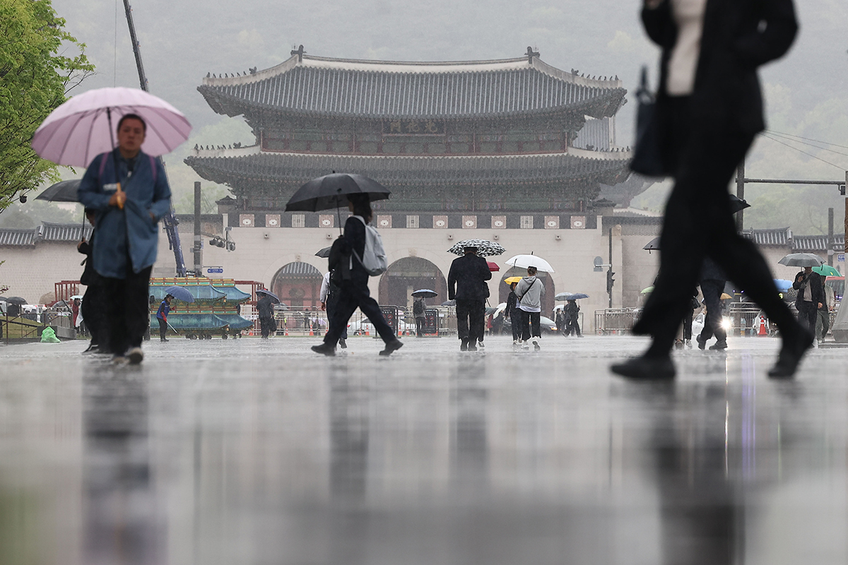 Sáng hôm nay (15/4), thành phố Seoul đã đón cơn mưa rào nặng hạt và hình ảnh người dân cầm ô bước vội trên đường đi làm ở quảng trường Gwanghwamun, quận Jongno-gu, Seoul. (Ảnh: Yonhap News)