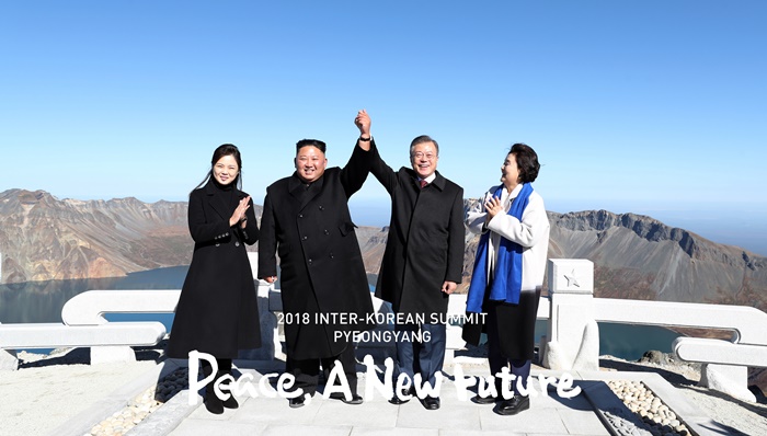 Tổng thống Hàn Quốc Moon Jae-in và Chủ tịch Ủy ban Quốc vụ Bắc Triều Tiên Kim Jong Un đang giơ tay lên tại đỉnh Janggun của núi Baekdusan. (Ảnh: Đoàn phóng viên lấy tin chung về Bình Nhưỡng)