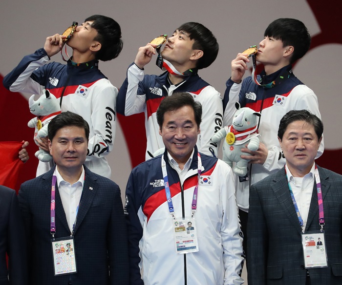 3 vận động viên Taekwondo Hàn Quốc Han Yeonghun, Kim Seonho và Kang Wanjin đang chụp ảnh kỷ niệm với Thủ tướng Hàn Quốc Lee Nak-yon trong lễ trao thưởng môn bài quyền (Poomsae) Taekwondo của Đại hội Thể thao châu Á Jakarta-Palembang 2018 diễn ra ở Trung tâm Hội nghị Jakarta, Indonesia vào ngày 19/8. (Ảnh: Yonhap News)