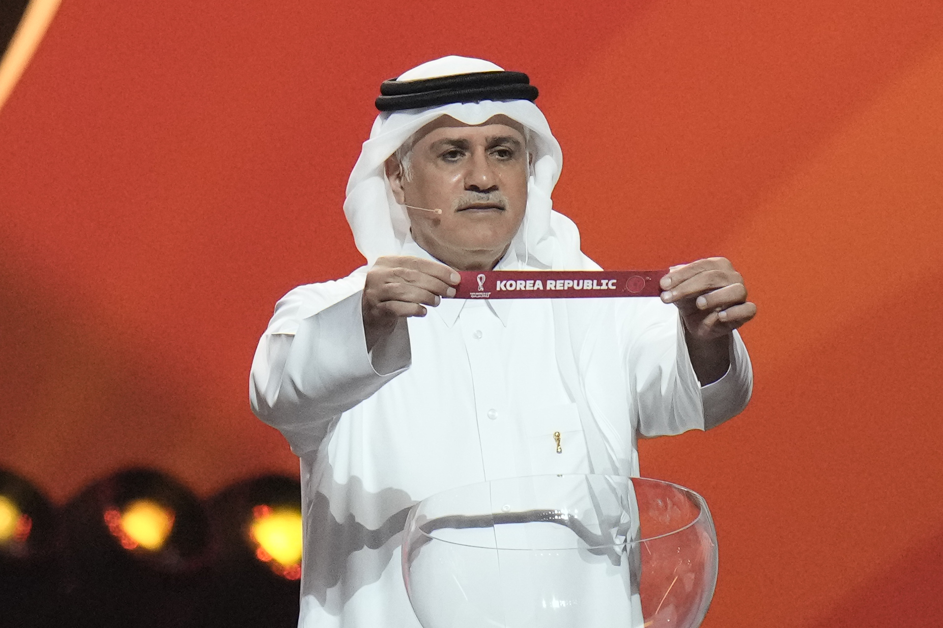 Một cựu cầu thủ Qatar Adel Ahmed MalAllah giơ lên lá thăm đặt đội bóng đá Hàn Quốc vào bảng H trong lễ bốc thăm chia bảng World Cup 2022 được tổ chức ở Trung tâm Hội nghị Quốc gia Qatar ở thủ đô Doha, Qatar. (Ảnh: Yonhap News)