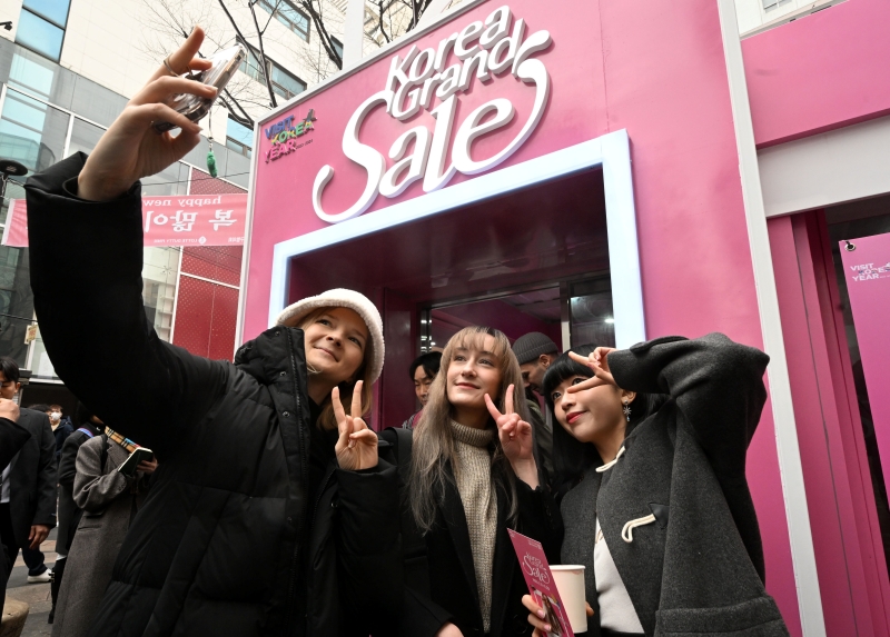 Trong lễ hội “Korea Grand Sale 2024”, du khách nước ngoài chụp ảnh selfie ở phía trước trung tâm “Welcome Conter” được lắm đặt tại khi Myeongdong, quận Jung-gu, thành phố Seoul vào ngày 11/1/2024. (Ảnh: Yonhap News) 