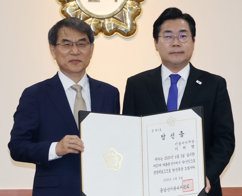 Chủ tịch Ủy ban Bầu cử Quốc gia Hàn Quốc (NEC) Roh Tae-ak (bên trái) vào ngày 4 tháng 6 đã trao tặng giấy xác nhận ông Lee Jae-myung đắc cử Tổng thống Hàn Quốc lần thứ 21 cho lãnh đạo đảng Dân chủ ông Park Chan-dae tại trụ sở chính của NEC, thành phố Gwacheon, tỉnh Gyeonggi-do. (Ảnh: Yonhap News)