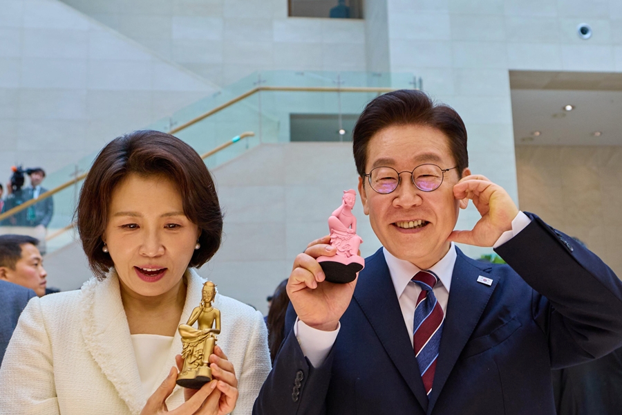 Tổng thống Lee Jae Myung (bên phải) và phu nhân Kim Hye Kyung chụp ảnh lưu niệm với các sản phẩm văn hóa của bảo tàng tại khu bán hàng lưu niệm sau khi tham quan triển lãm đặc biệt “Yi Sun-sin”, diễn ra ngày 26/2 tại Bảo tàng Quốc gia Hàn Quốc ở quận Yongsan, Seoul. (Ảnh: Nhà Xanh)