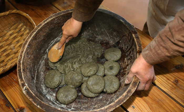 삶아낸 오메기떡은 건져서 나무주걱으로 덩어리가 없을 때까지 치대야 한다.