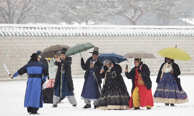 Khách du lịch nước ngoài mặc Hanbok chụp ảnh dưới trời tuyết trắng