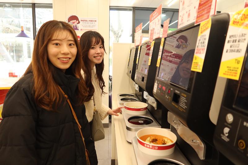 Hai du khách Nhật Bản đã trải nghiệm nấu mì tôm tại Thư viện Ramyun ở cửa hàng tiện lợi CU Hongdae Sangsang, quận Mapo-gu, Seoul. (Ảnh: Hong Angie) 