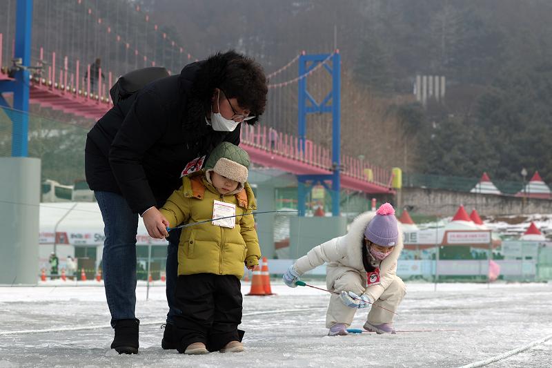 14일 강원 화천군 화천천 일원에서 열린 '2025 얼음나라 화천산천어축제'를 찾은 가족 관광객이 산천어축제를 즐기고 있다.