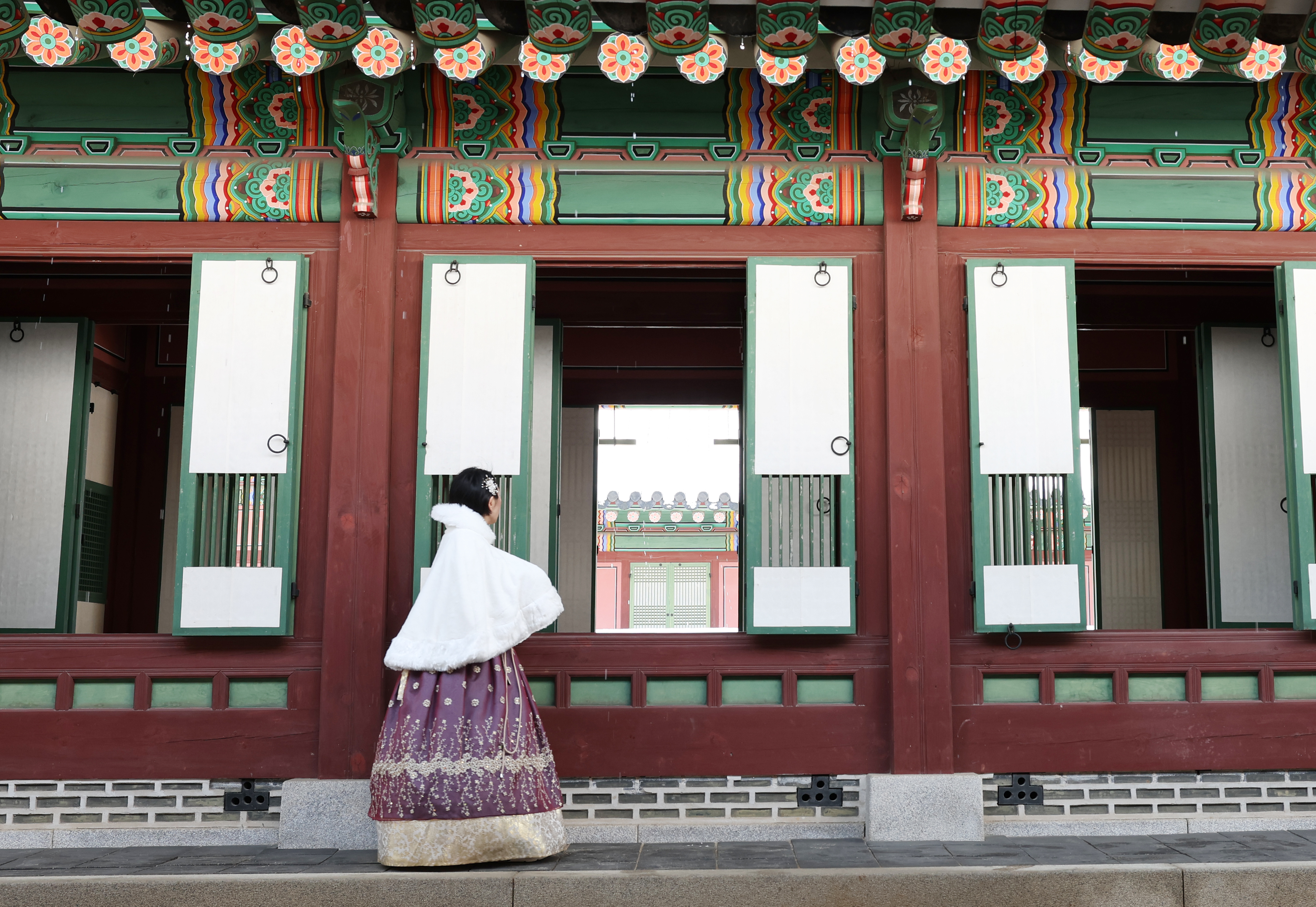 Ngày 18/3/2025, một du khách mặc Hanbok (trang phục truyền thống Hàn Quốc) nhìn vào bên trong một tòa nhà ở cung điện Changdeokgung, quận Jongno-gu, thành phố Seoul. 