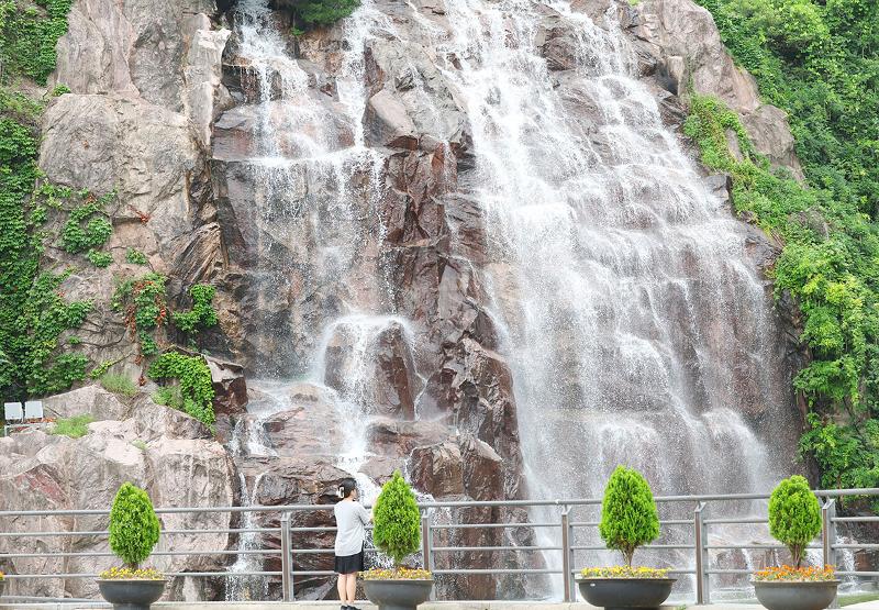  Vào tiết Tiểu thử (ngày 7/7/2025), một người dân đến tham quan Công viên Thác nuớc Yongma, quận Jungnang-gu, thành phố Seoul.