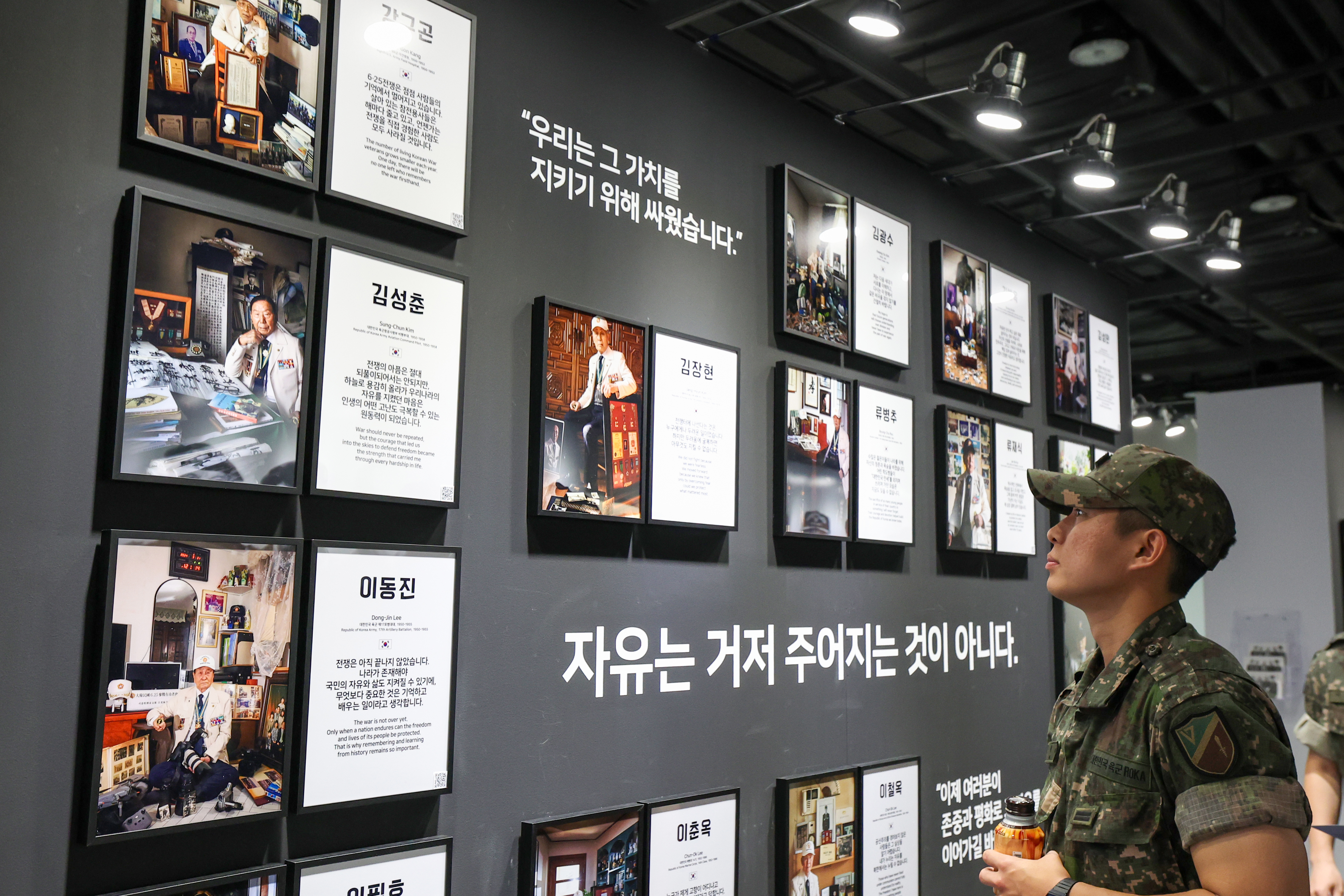Ng&agrave;y 19/6, tại triển l&atilde;m ảnh &ldquo;Project Soldier - Triển l&atilde;m ảnh tri &acirc;n cựu binh tham chiến trong Chiến tranh Triều Ti&ecirc;n&rdquo; diễn ra tại ph&ograve;ng triển l&atilde;m chuy&ecirc;n đề của Bảo t&agrave;ng Chiến tranh ở quận Yongsan, Seoul, một qu&acirc;n nh&acirc;n đang ngắm&nbsp;ảnh ch&acirc;n dung của c&aacute;c&nbsp;cựu binh tham chiến trong Chiến tranh Triều Ti&ecirc;n. (Ảnh: Lee Jeong Woo)
