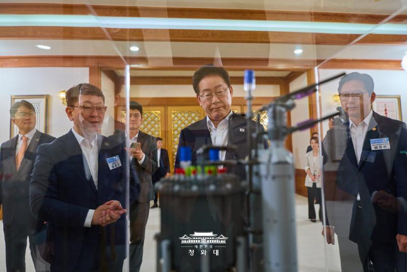 Tổng thống Lee Jae Myung (thứ hai từ tr&aacute;i sang, h&agrave;ng trước) xem m&ocirc; h&igrave;nh t&agrave;u container trang bị l&ograve; phản ứng m&ocirc;-đun nhỏ (SMR) trước khi tham dự Hội nghị b&aacute;o c&aacute;o &ldquo;7 SEED - Động lực tăng trưởng tương lai&rdquo; tại Nh&agrave; Xanh ng&agrave;y 12/8. (Ảnh: Nh&agrave; Xanh)